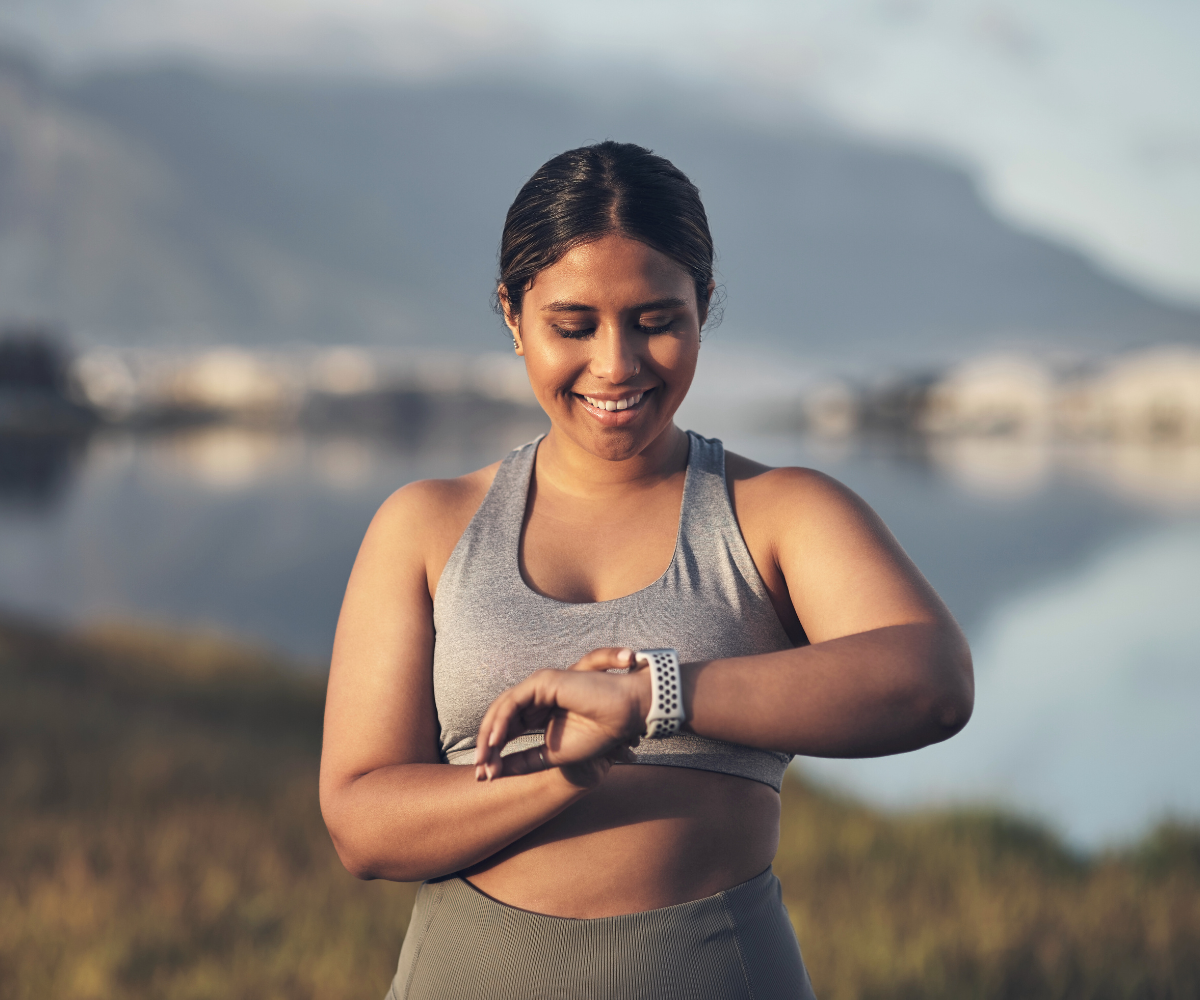 A woman checks her fitness watch on a run.