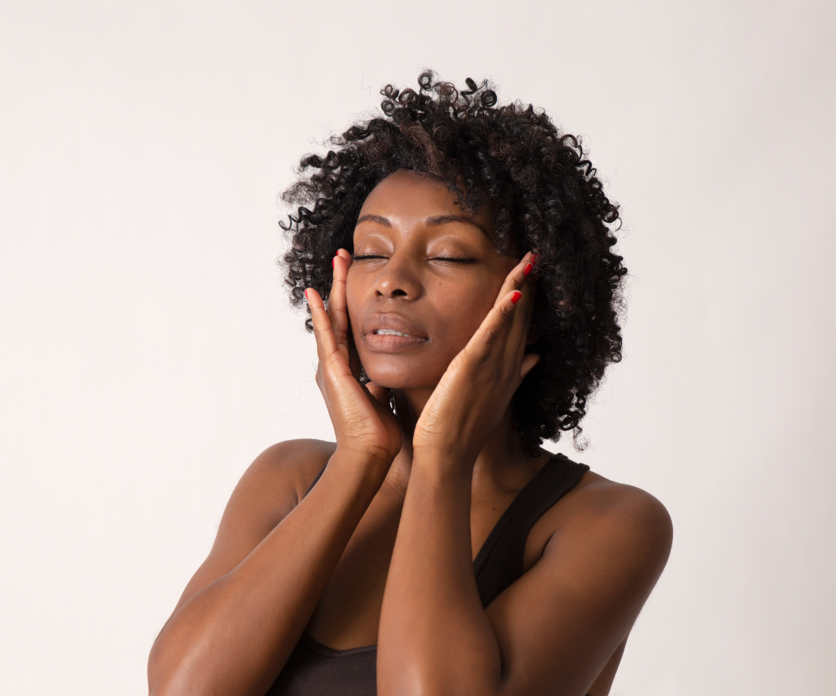 A woman applies GHK copper peptides to her face